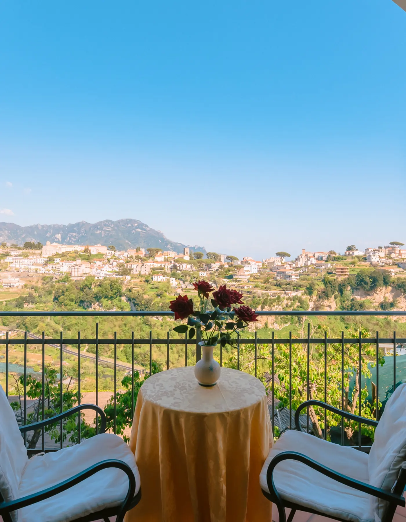 Una terrazza di Villa Giuseppina vista da dentro un arco, con tavolino e sedie sul panorama